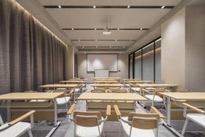an empty classroom with tables and chairs and a whiteboard at Ibis Shanghai Expo Dongming Road Metro Station in Shanghai