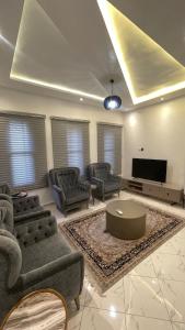 uma sala de estar com sofás e uma TV de tela plana em Modern 3BR Oasis right on Lekki-Ikoyi em Araromi