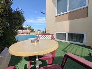 a patio with a table and chairs and a pool at Flatlet in a Villa with pool in Naxxar +4 photos