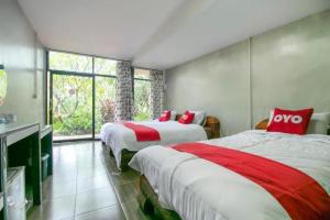 - une chambre avec 2 lits dotés de draps rouges et blancs dans l'établissement OYO 1140 Piyapruk Resort at Khaoyai, à Ban Khanong Phra Klang (1)