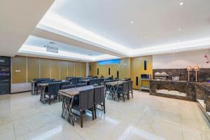 un restaurant avec des tables et des chaises dans une salle dans l'établissement Lavande Hotels Harbin Shimao Avenue Wanda, à Harbin 216 autres photos
