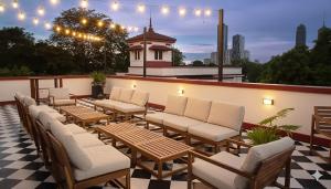 una fila di sedie e tavoli su un patio di MiraNamin Nest KAMANTIGI - Two Bed Suite in Historic Home with Luxury Indoor Plunge Pool, Garden Access, Self-Service Breakfast, Guest Kitchen, Pet-Friendly a Manila