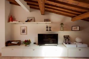 uma sala de estar com uma televisão de ecrã plano num armário branco em Casa Cosi Masaccio em Florença