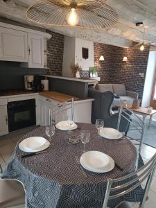 una mesa con platos y vasos en ella en una cocina en Gîte l'orée de la forêt légendaire, en Néant-sur-Yvel