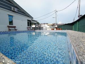 a swimming pool with blue tiles on top of a house at Teratak Saharah Homestay in Port Dickson
