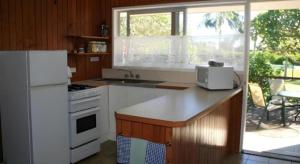 une cuisine avec des appareils blancs et une grande fenêtre dans l'établissement Fletcher Christian Holiday Hotel, à Kingston