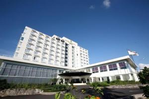 un grand hôtel blanc avec un grand bâtiment dans l'établissement Sintesa Peninsula Hotel, à Manado