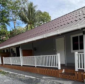 a house with a white porch and a roof at Pradu House Koh Yao Noi in Ko Yao Noi
