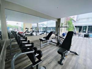 a gym with a row of treadmills and chairs at Avenue Suites in Bacolod