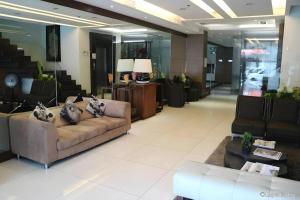 a lobby with couches and tables in a building at Avenue Suites in Bacolod +244 photos