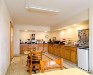 a large kitchen with a table and chairs and a counter at SureStay Hotel in Salina