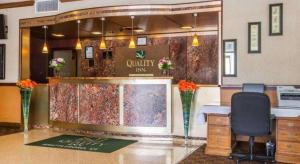 a lobby of a hotel with a counter with flowers at Quality Inn & Conference Center in West Chesterfield