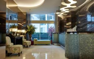 a lobby of a hotel with a reception desk and chairs at d'primahotel Mega Kuningan in Jakarta +243 photos