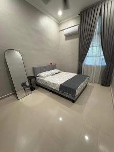 Un dormitorio con una cama y un espejo y una ventana. en Peruda Inn - Homestay for Múslim only, en Sungai Petani