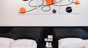 a bedroom with two beds and a sign on the wall at Noble Park Hotel in Hong Kong +126 photos