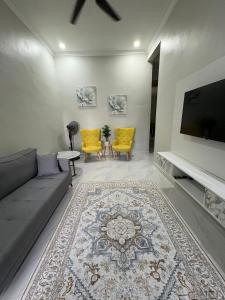 Una sala de estar con un sofá y sillas y un televisor. en Peruda Inn - Homestay for Múslim only, en Sungai Petani 12 fotos más