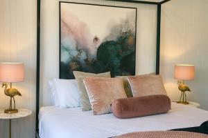 une chambre avec un lit avec un tableau sur le mur dans l'établissement 5 Bed 5 Bath Urban Getaway Ipswich Central, à Ipswich