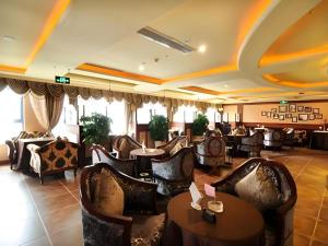 a restaurant with couches and tables and chairs at Chengdu French Theme Gold Palace in Chengdu