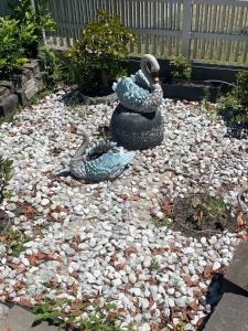 two statues of peacocks on a bed of rocks at Salisbury Suburban Escape in Brisbane +4 photos
