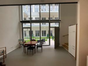 a room with a table and chairs and a large window at moderne Loft in Vienna +39 photos