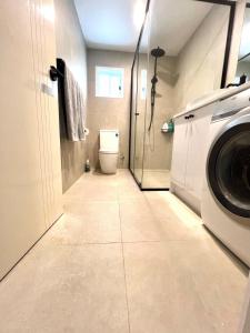 a bathroom with a washing machine and a toilet at Salisbury Suburban Escape in Brisbane
