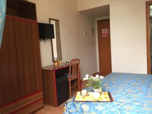 um quarto de hotel com uma cama e uma mesa com flores em Hotel Altavilla Dieci em Roma
