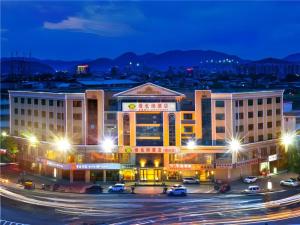 a hotel with cars parked in a parking lot at night at Vienna Hotel Meizhou Mei County Airport in Meizhou