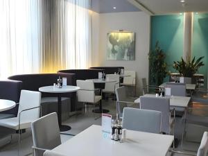 a dining room with white tables and chairs at Jinjiang Inn Changchun Pepole Square in Changchun
