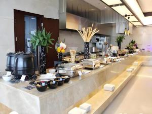 - une ligne de buffet dans une cuisine avec de la nourriture dans l'établissement Fuzhou Fliport Garden Hotel, à Xianqi