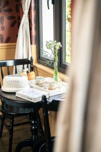 a table with a vase of flowers and a window at Nàng Homestay Studio in Thu Dau Mot