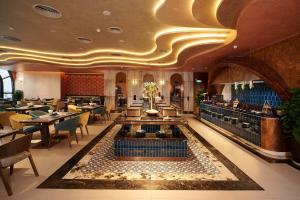 a restaurant with a lobby with tables and chairs at Champton Nha Trang Hotel in Nha Trang