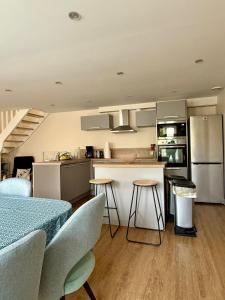a kitchen with a table and some chairs in a room at L'escale Granvillaise in Granville