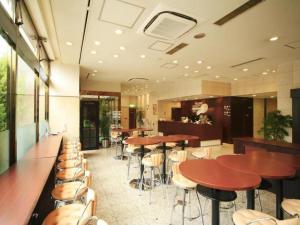 a restaurant with tables and chairs in a room at Nagoya B's Hotel in Nagoya