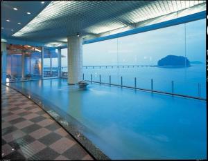 an empty swimming pool with a view of the water at Hotel Takeshima in Gamagori
