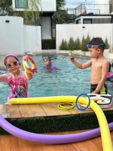 two children playing in a pool with their toys at My Room by Sermsub in Aranyaprathet