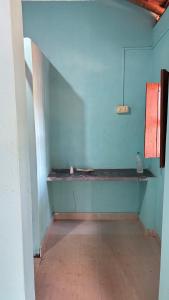 an empty room with a blue wall and a shelf at Dream way homestay in Gokarna