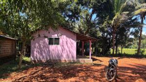 a pink house with a motorcycle parked in front of it at Dream way homestay in Gokarna