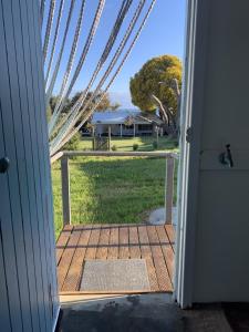 - une porte ouverte sur une terrasse couverte offrant une vue sur la cour dans l'établissement The Beach Cottage - close to beach and river mouth, à Guilderton 2 autres photos