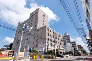 a tall white building on a city street at Albert Hotel in Dote-nagamachi