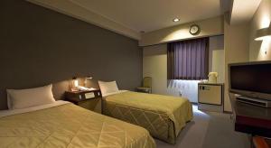 Postel nebo postele na pokoji v ubytování Shizuoka UI Hotel