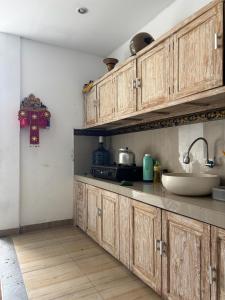 a kitchen with wooden cabinets and a sink at Ika Homestay 2 in Canggu