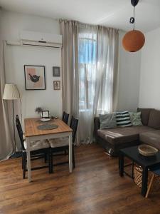 a living room with a table and a couch at Radomir Downtown 1-bedroom Apartment with balcony in Bŭnzareto +2 photos