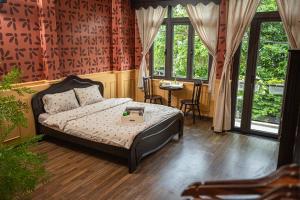 a bedroom with a bed and a table and windows at Nàng Homestay Studio in Thu Dau Mot