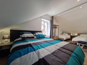 a bedroom with a striped bed and a window at Gite Mirabelle in Moyenmoutier