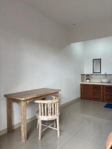 a wooden table and a chair in a room at Ika Homestay 2 in Canggu