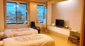 a hotel room with two beds and a television at Ryokan Yasuda-Onsen Yasuragi Agano in Agano +105 photos