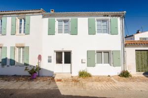 a white house with green shutters on it at Chambres d’hôtes Chantal Hereaudeau in Les Moulins de la Boire