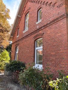 ein Backsteingebäude mit einem Seitenfenster in der Unterkunft Ostfriesland-Haus in Jemgum + 11 Fotos
