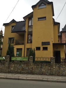 a yellow house with a stone wall at U Zubrytskyh in Truskavets