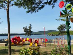 a playground next to a body of water at Riverine Garden Hotel in Kampong Gong Pauh